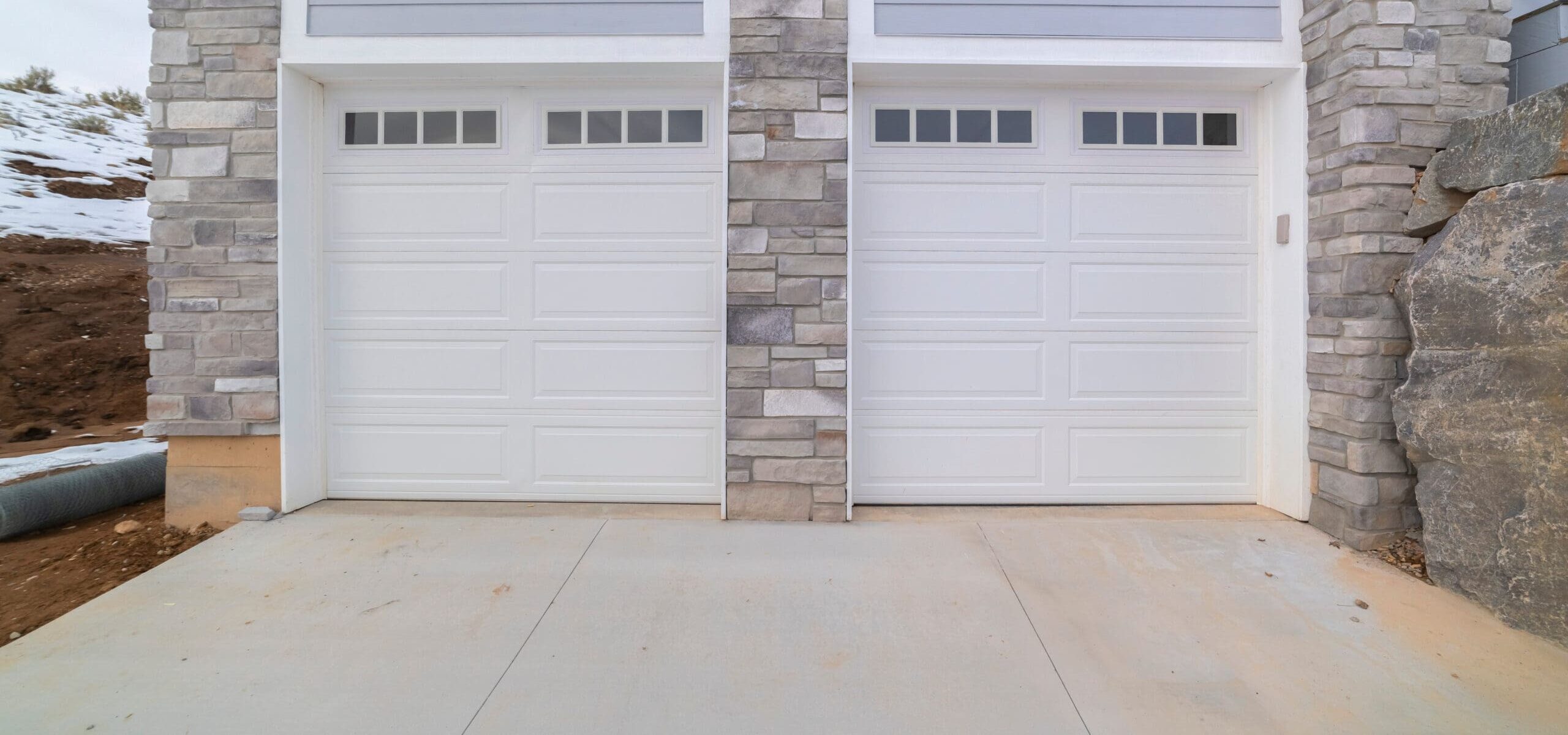 two single garages sharing a cement driveway